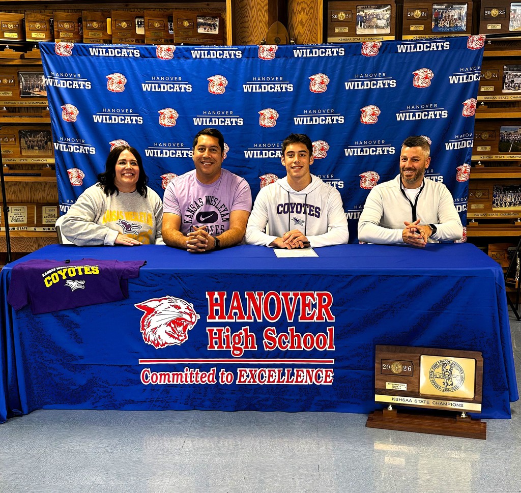 Braylon signs with parents, Chris and Renee, and Coach Cory Jensen looking on.