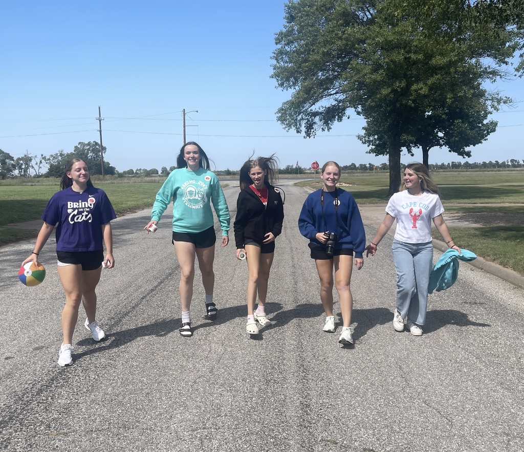 picture of five students walking down a street