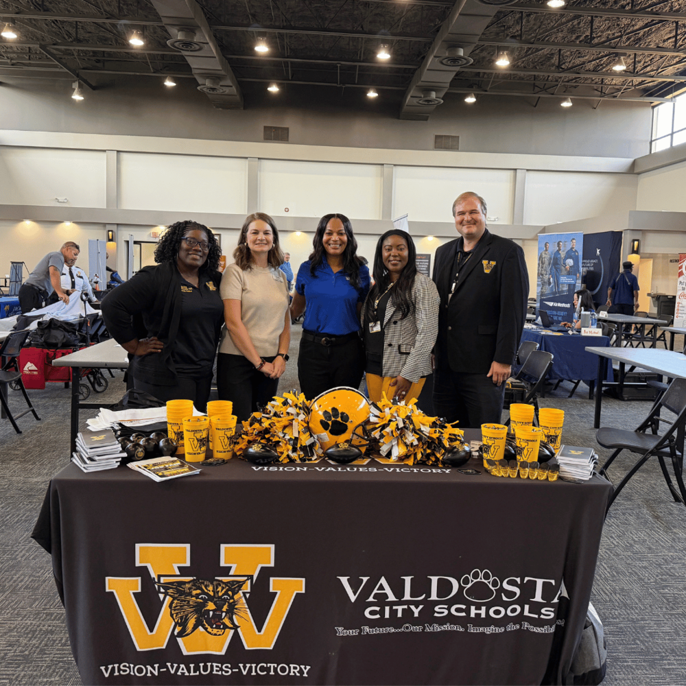 group photo of VCS employees and board member in front of VCS table