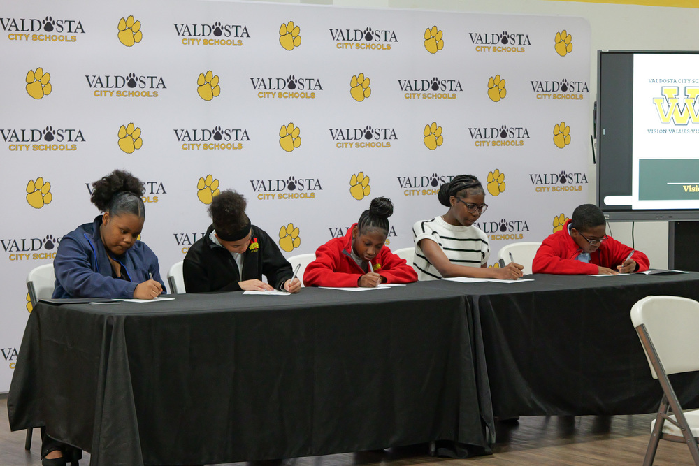 students signing  contracts