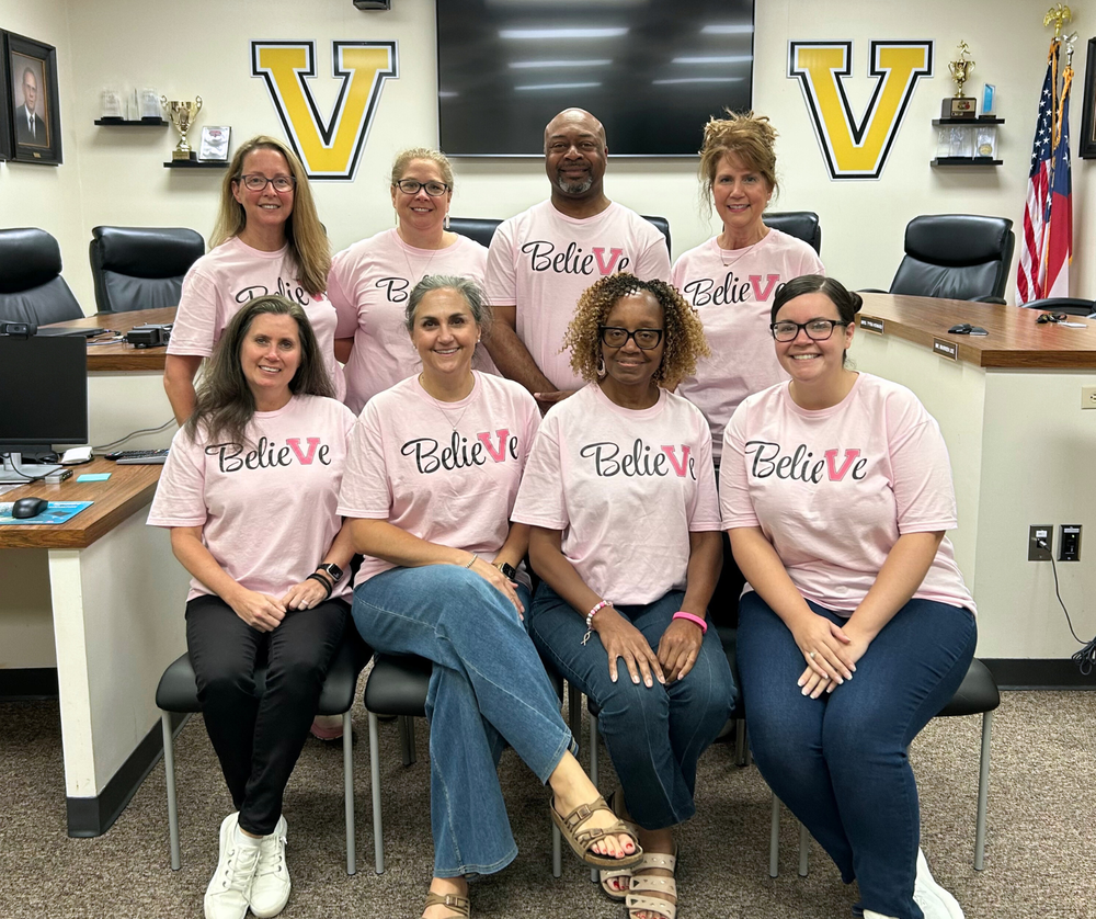 Group photo of staff in the pink t-shirts