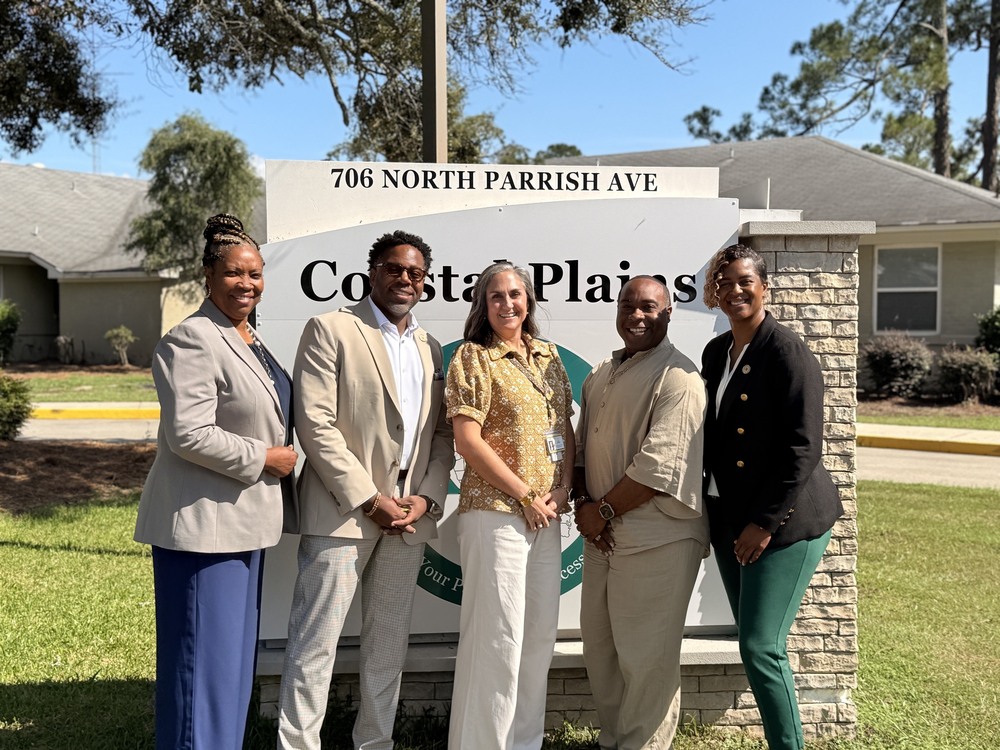 group photo of participants in front of Coastal Plains sign
