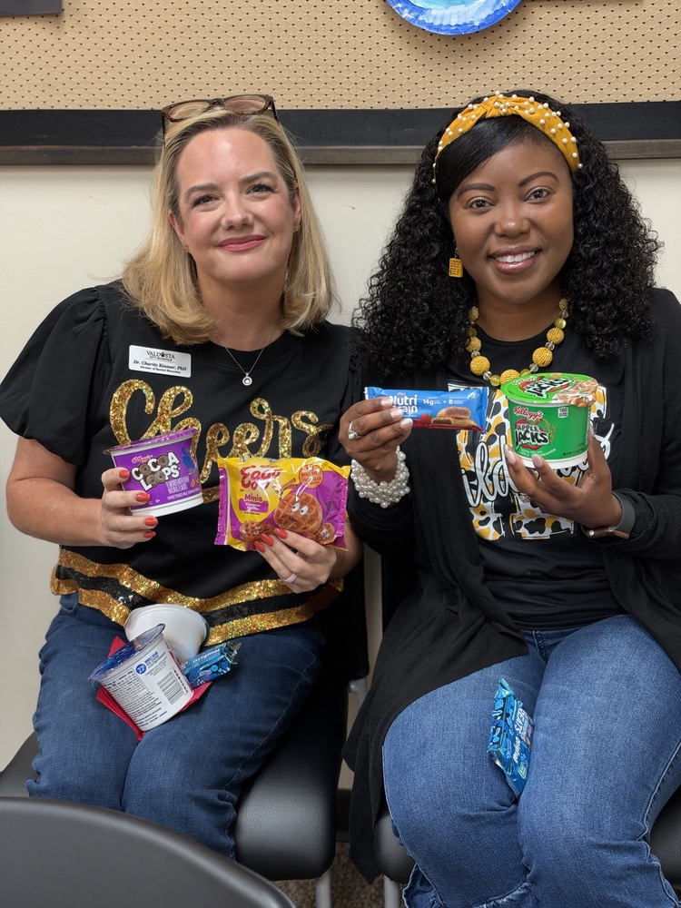 two employees holding breakfast food