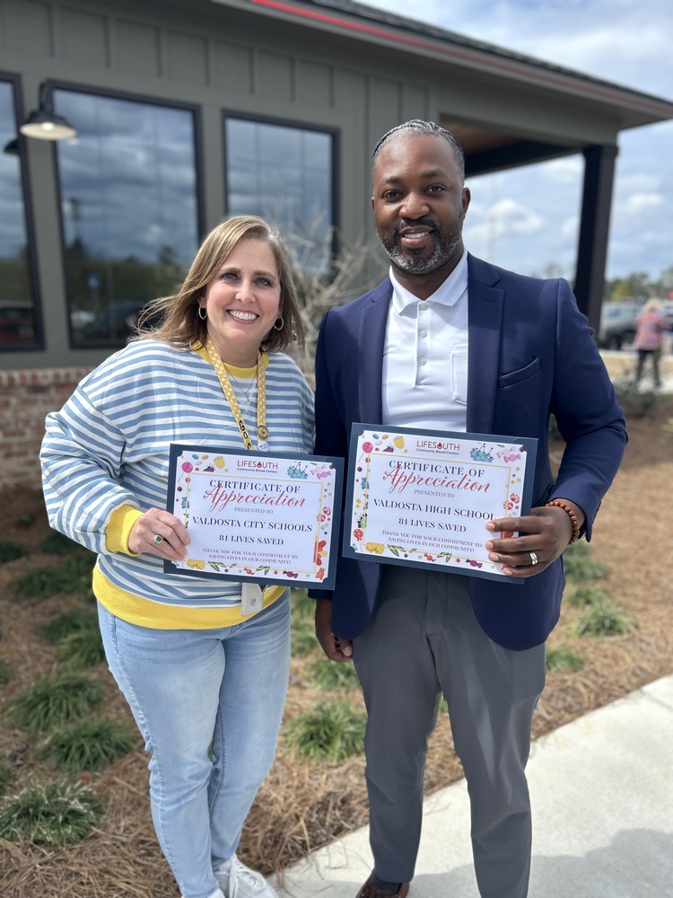 staff holding certificates