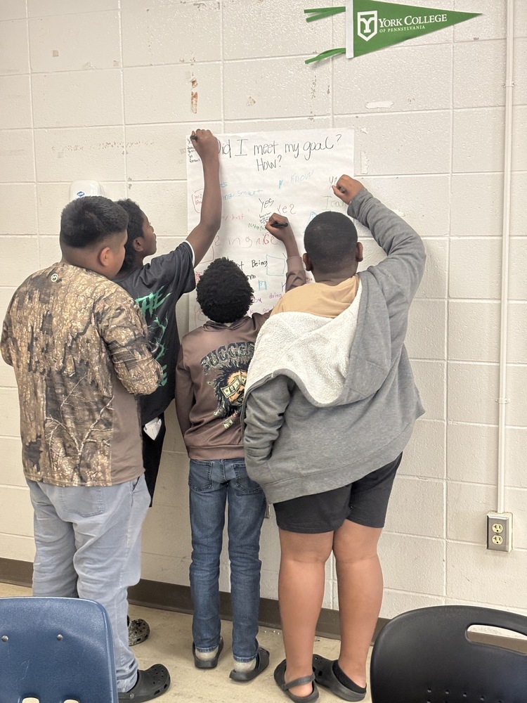 students writing goals on a large sheet of paper