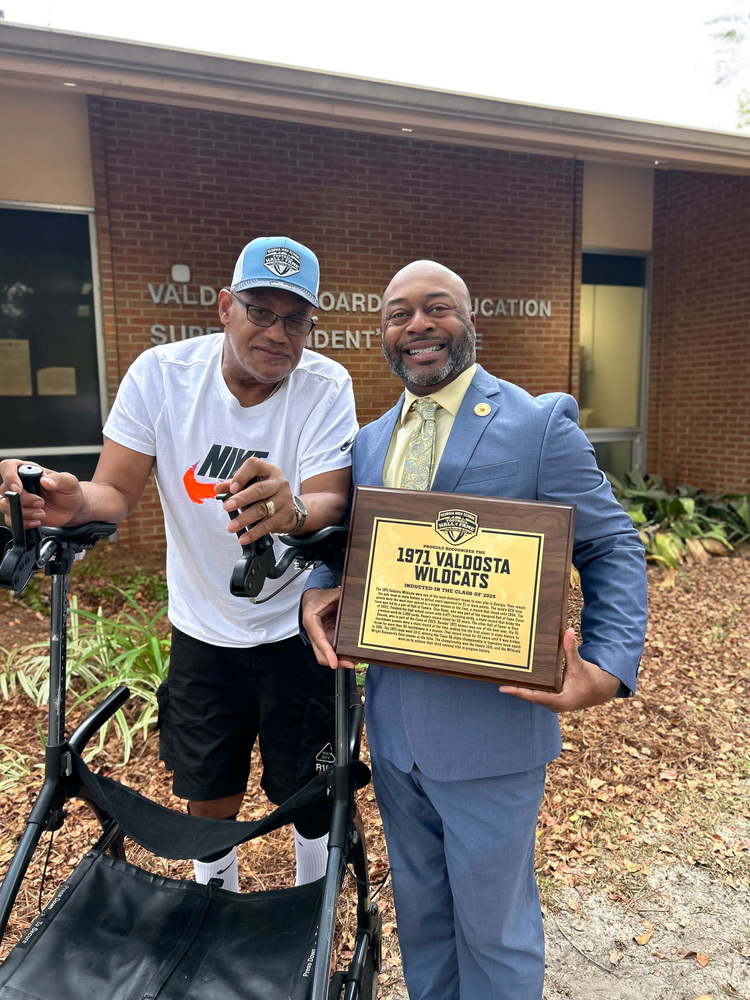 Superintendent holding plaque with Stan Rome