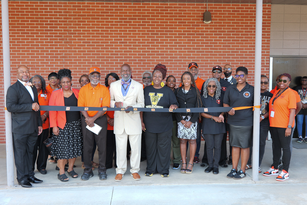 Group photo of officials holding the ribbon before they cut