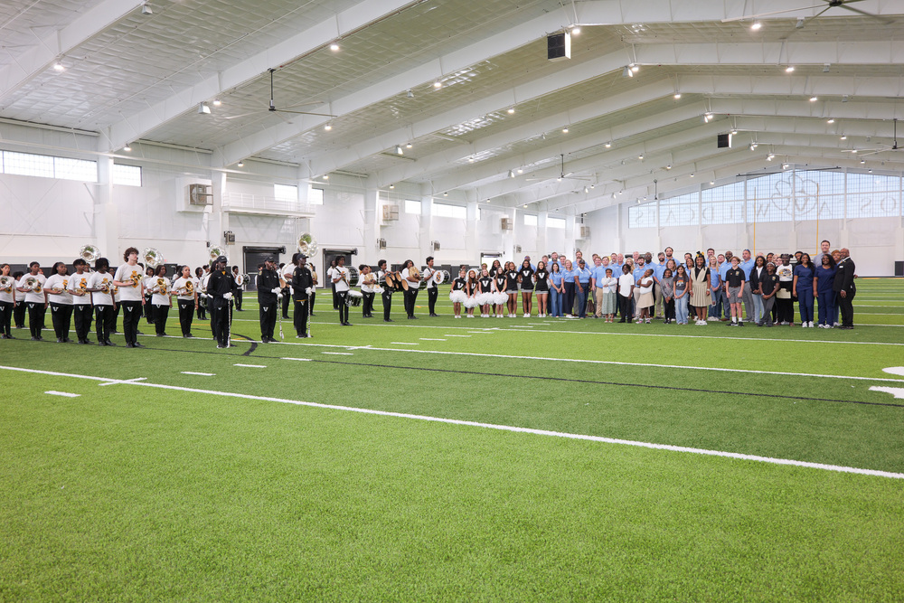 large group photo with LL, band, staff and students in indoor multipurpose facility