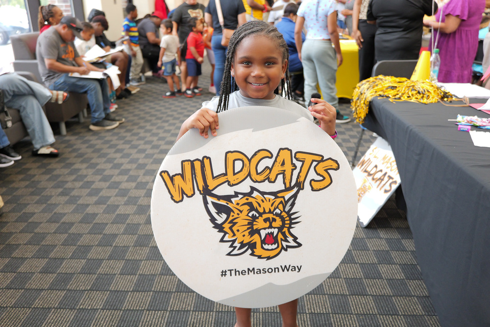 Student holding a Wildcats sign