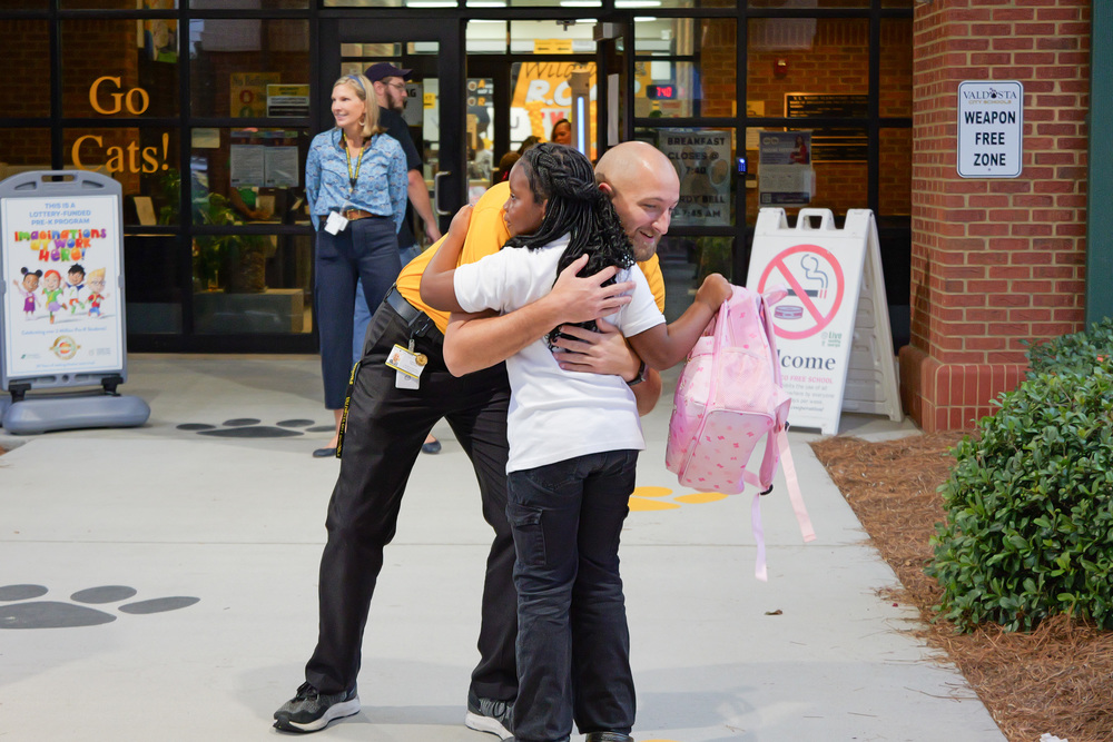 staff member hugging a student