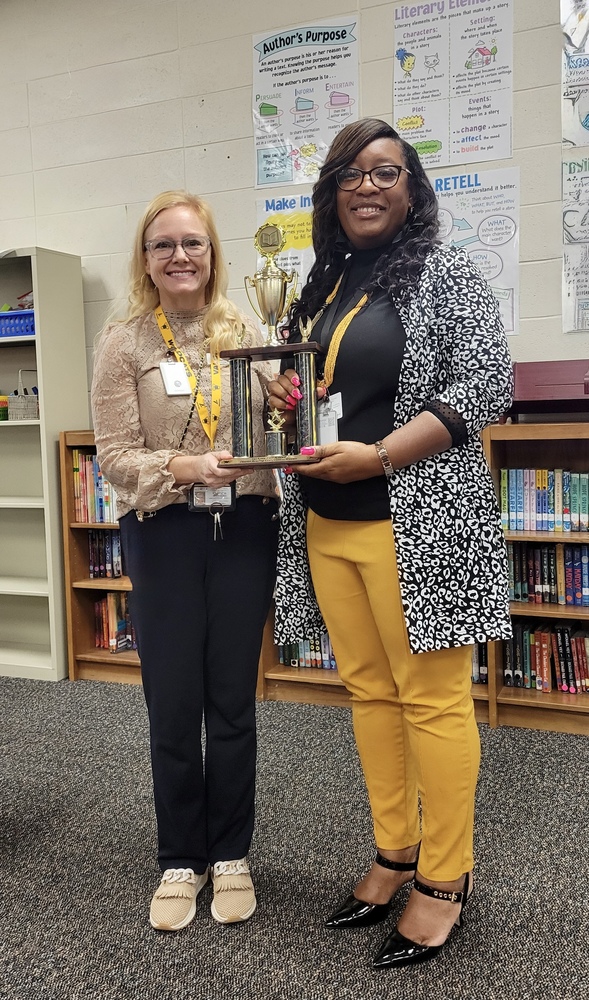 Dr. Crawford with JLN Principal holding trophy
