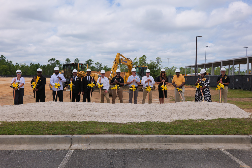 Group photo of participants holding shovels