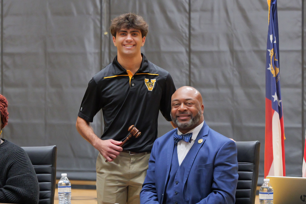 Student holding gavel with Superintendent