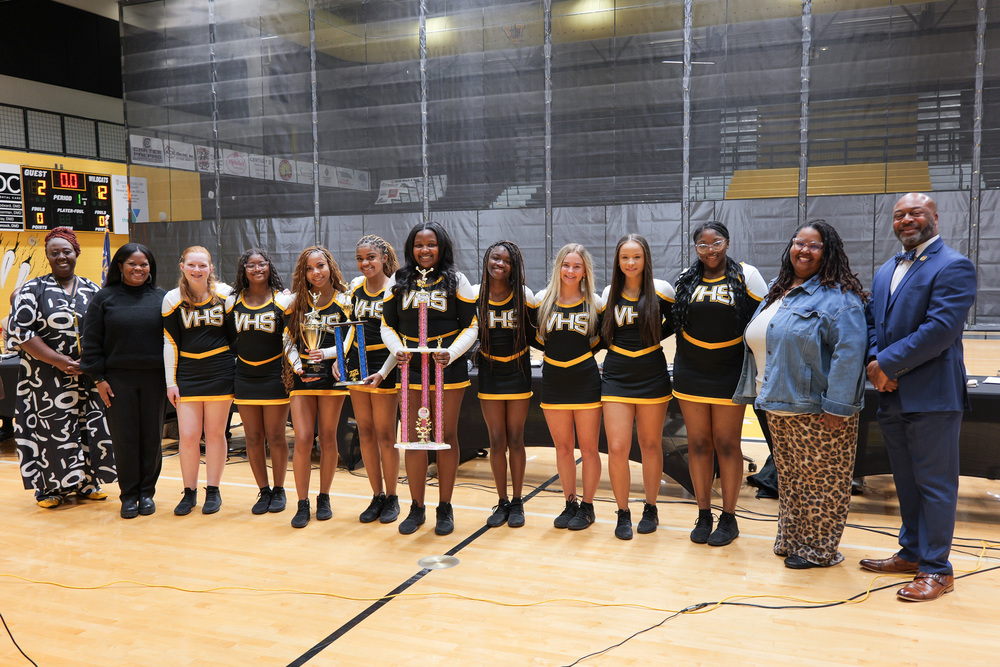 Group photo of cheerleaders with trophy, Superintendent, Coaches, and Board Chair