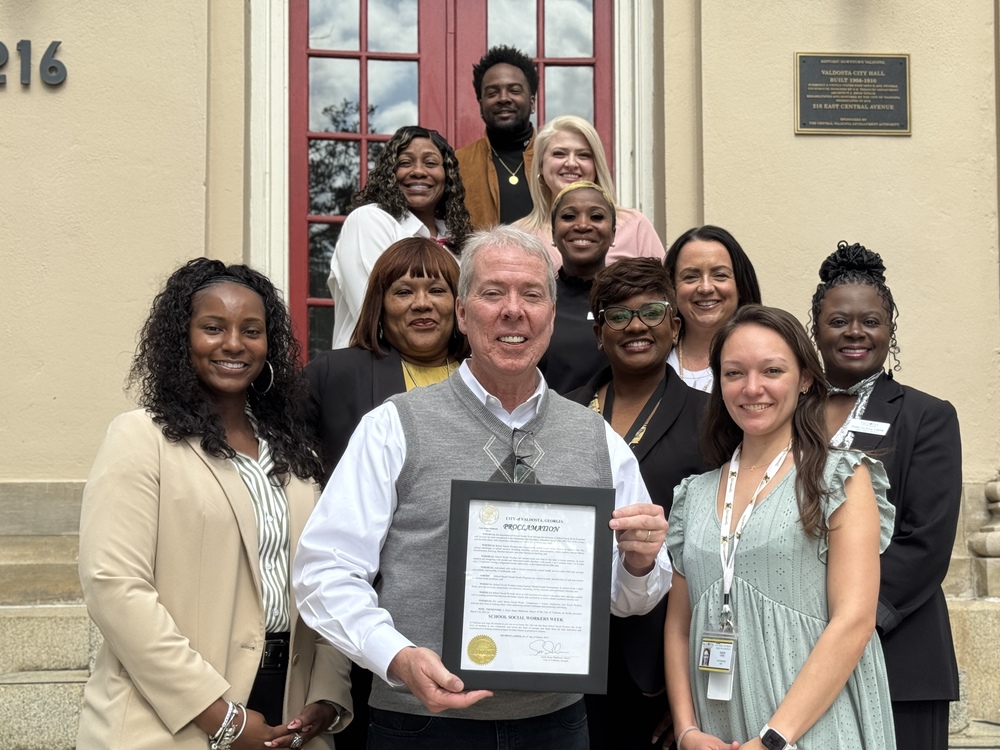 Group photo of school social workers with mayor, holding proclomation