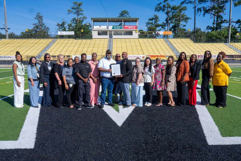 group photo on football field, holding proclamation