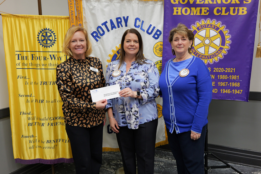 representatives from Rotary handing check to Dr. Crawford for the W.O.W. Bus