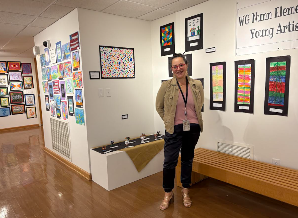 teacher standing in front of art display