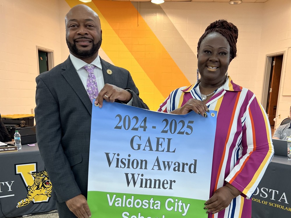 Dr. Lockhart and Board Chair holding banner