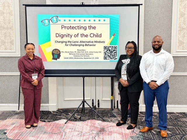 VCS specialists standing in front of their presentation on a screen