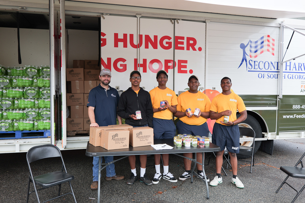 Group photo of students with Second Harvest holding cans of food