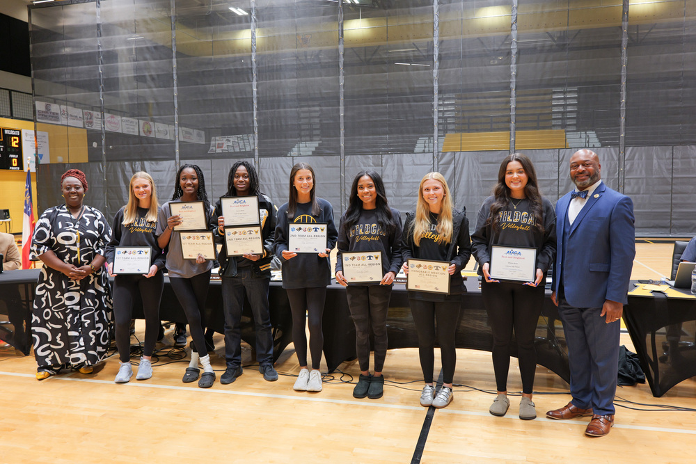 Group photo of volleyball players holding certificates with Superintendent and Board Chair