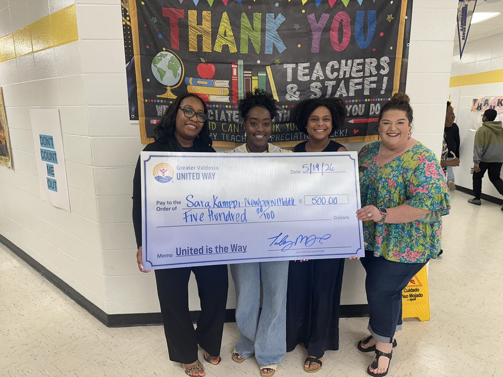 Newbern Librarian with Greater United Way Reps holding a giant check