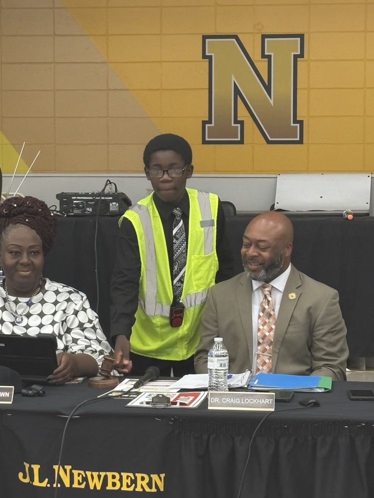student holding gavel with superintendent and board chair beside him