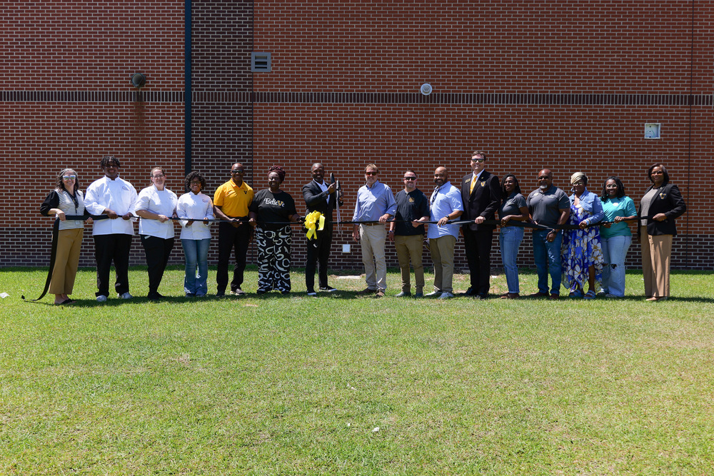 group photo with large ribbon and scissors