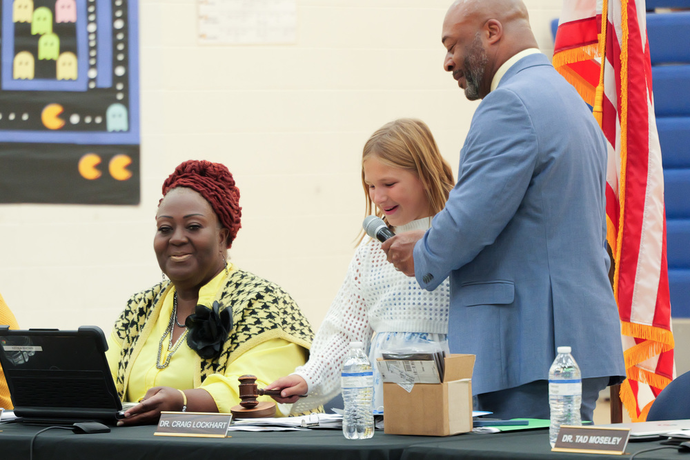 Student holding gavel with Board Chair and Superintendent