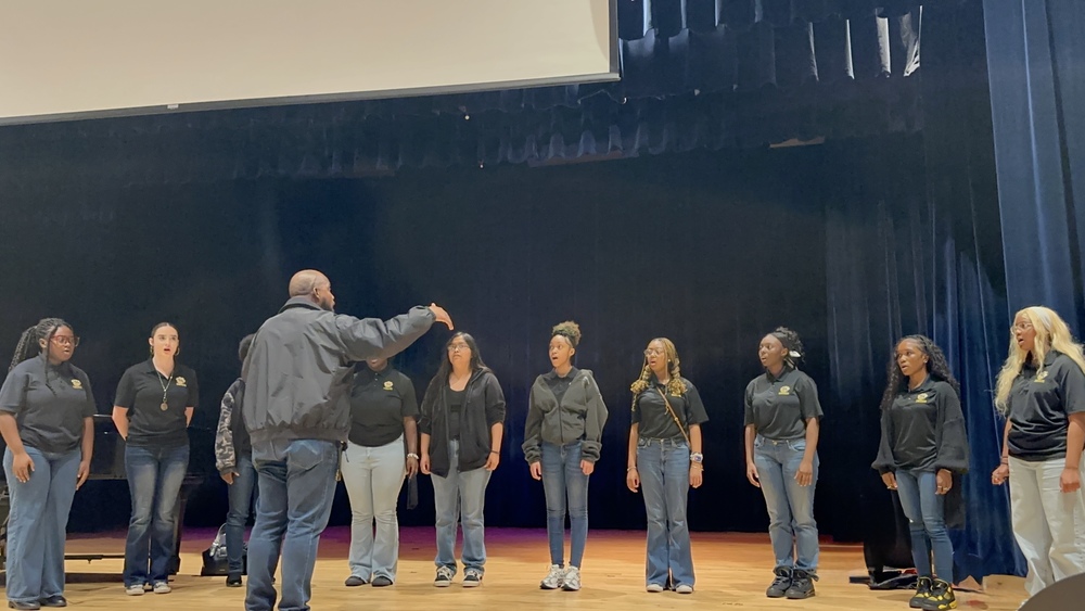 chorus students singing with direction of the director