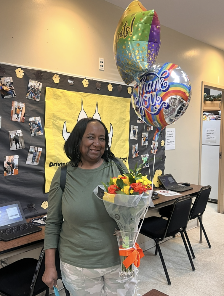 Staff member holding flowers and balloons