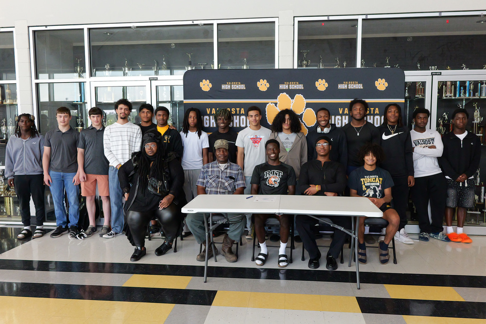 Group photo with student, his teammates and family