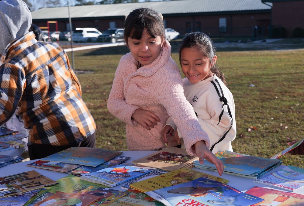 Students picking up books from the table