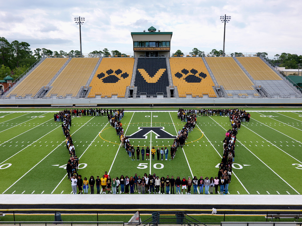 Group photo of freshmen forming the V on the football field