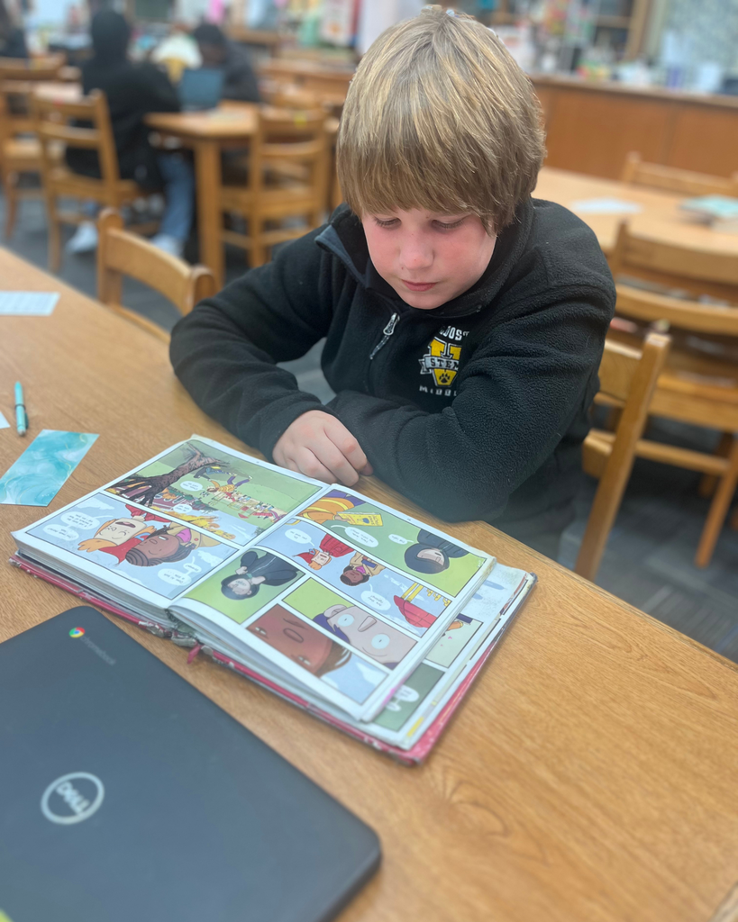 Student reading at a table in the library