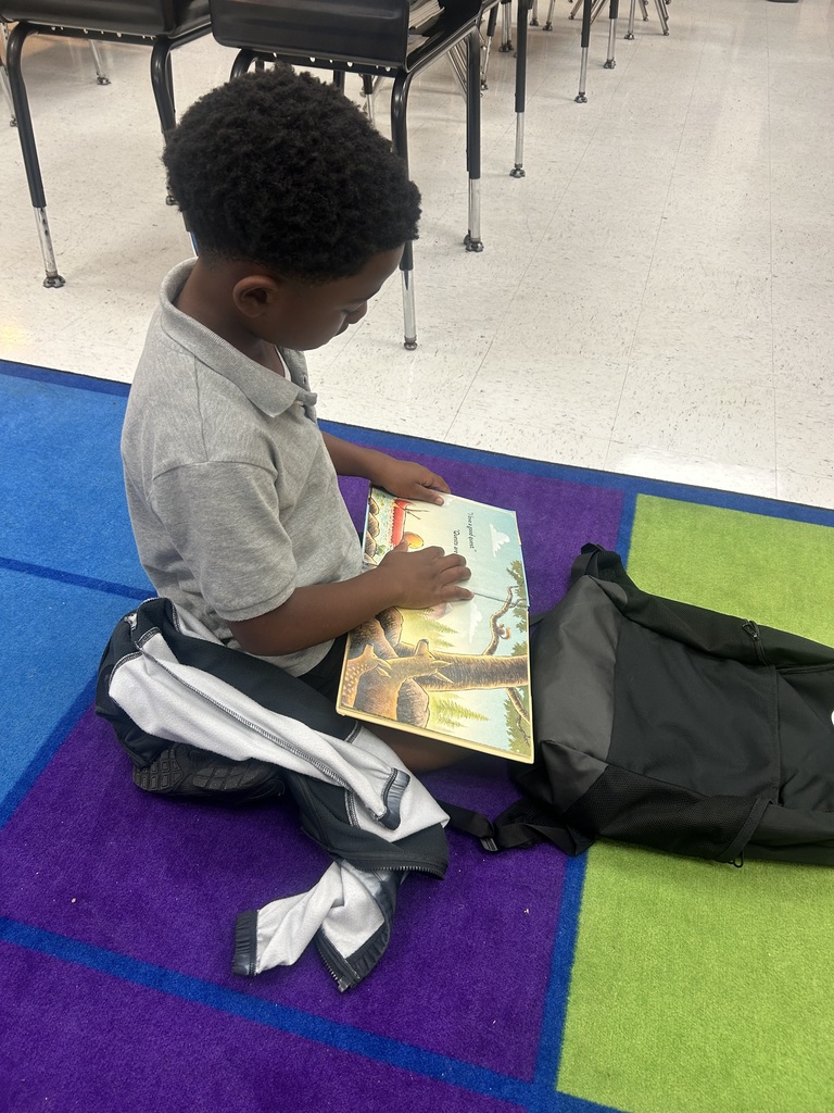 male student, reading on colorful rug