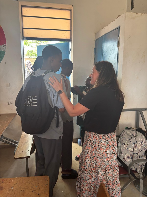 Mrs. Roberts with her hand on a students shoulder