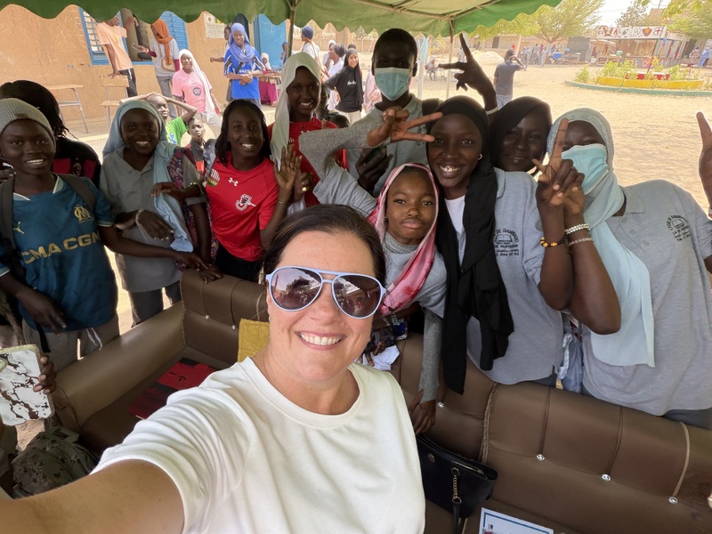 Mrs. Roberts smiling with a group of students