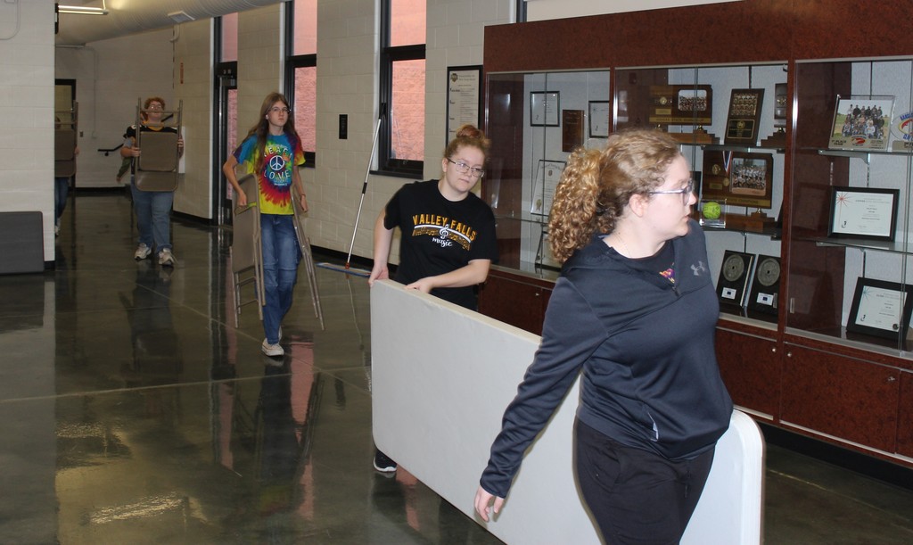 Students carrying tables