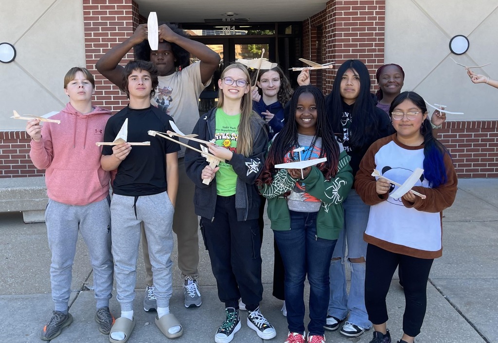 students holding gliders they created
