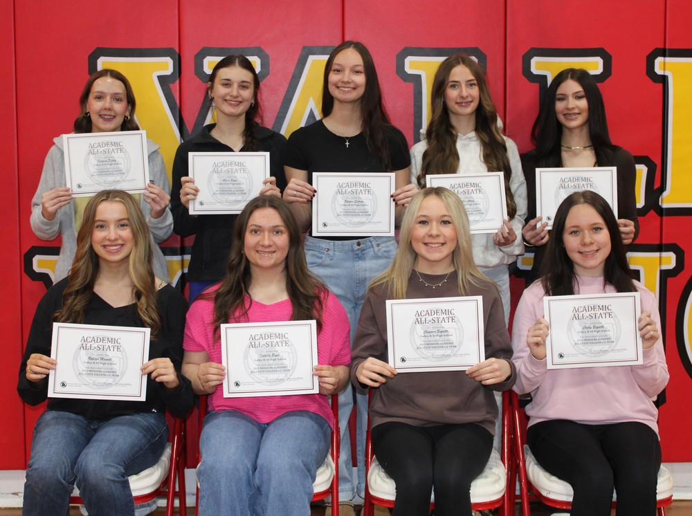 Volleyball players posing with certificates