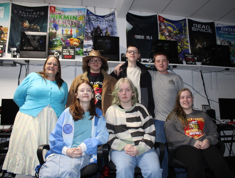 Students posing for picture in front of computers