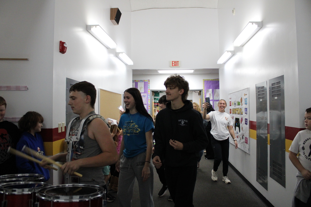 Student playing drums and walking in the hallways
