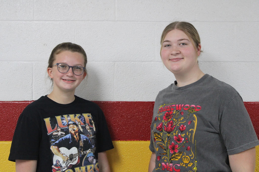Two Students Posing By Wall