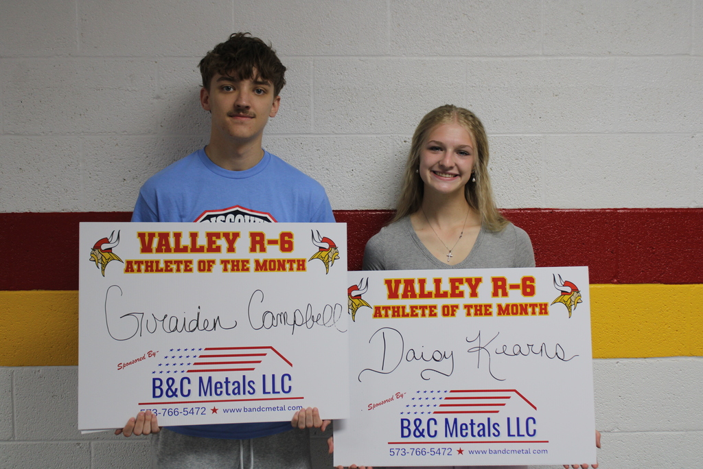 Students Posing with signs for Athlete of the Month