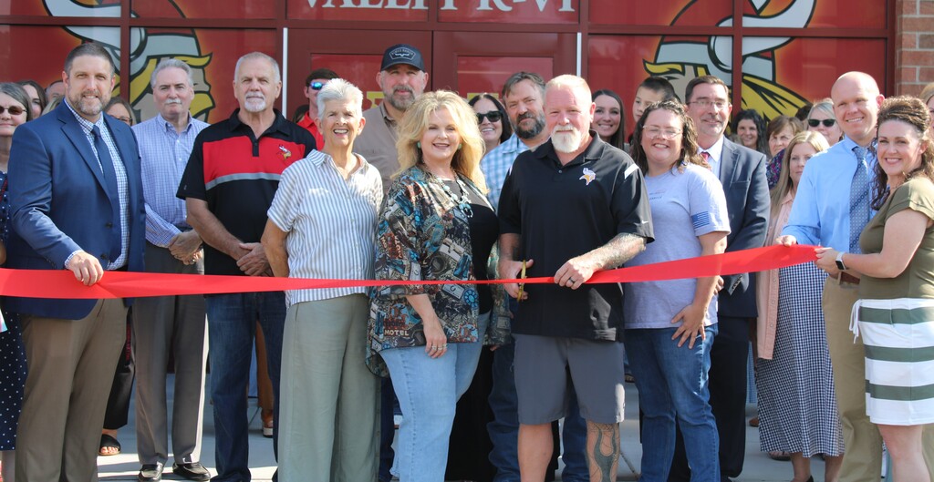 Group in front of building cutting a ribbon