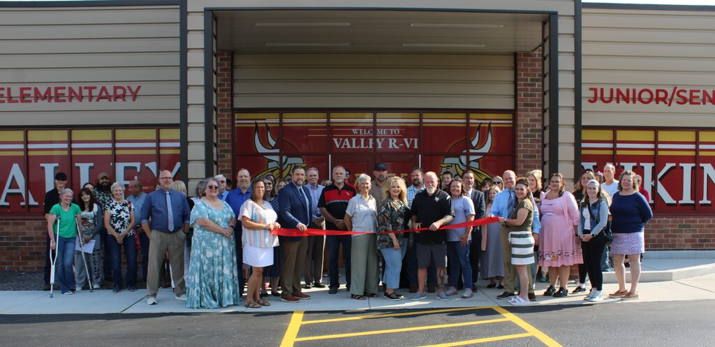 Group in front of building cutting ribbon