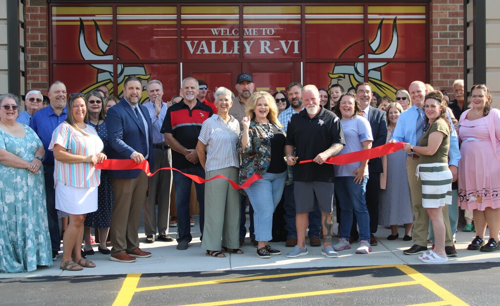 Group of people cutting a ribbon