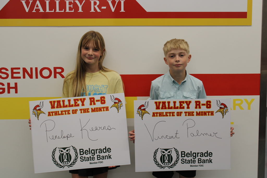Students posing in front of the wall for Athlete of the month